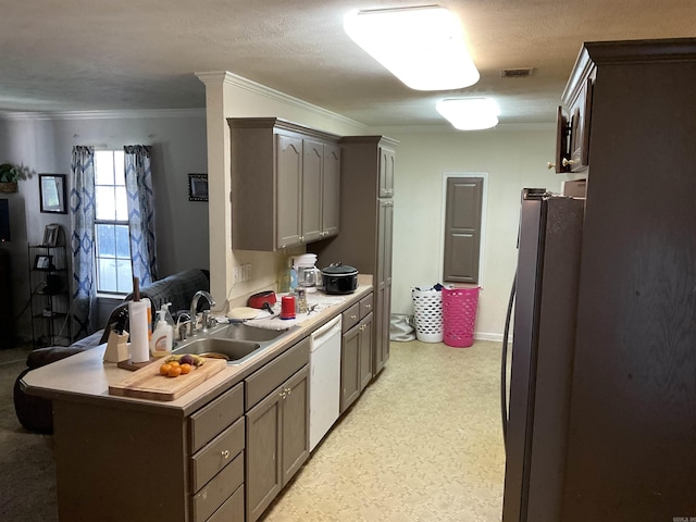 kitchen featuring freestanding refrigerator, a sink, dishwasher, crown molding, and light flooring