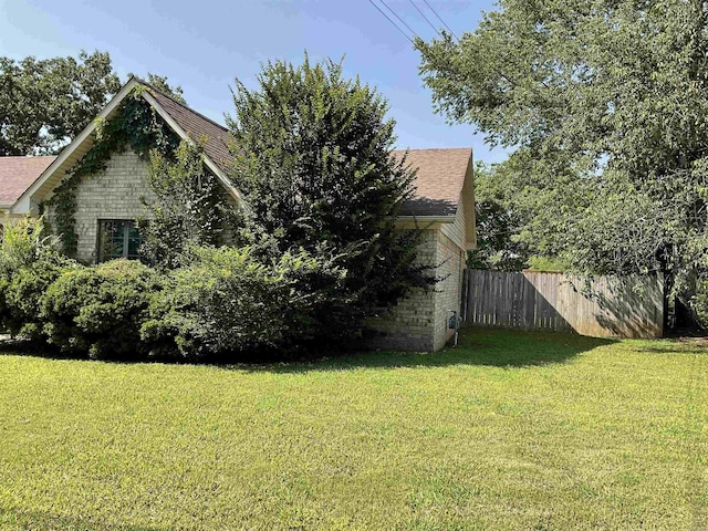 view of property exterior with brick siding and a shingled roof