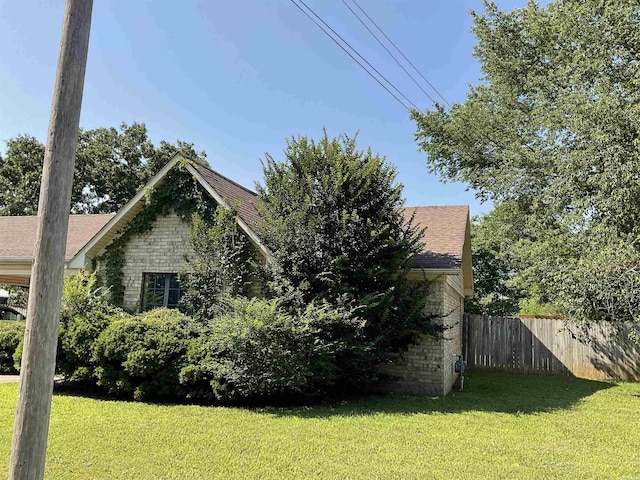 view of side of home with brick siding and roof with shingles