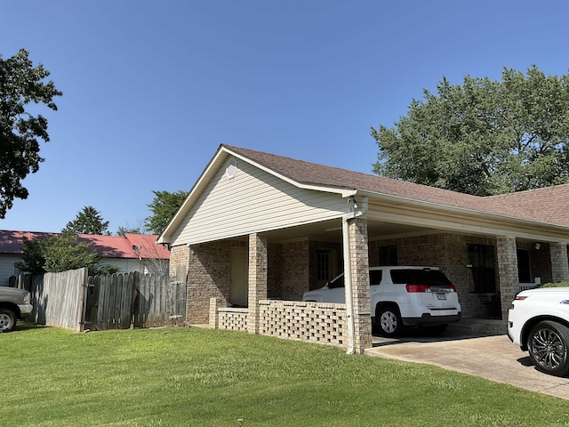 view of home's exterior with brick siding, an attached carport, driveway, and roof with shingles