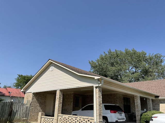 view of property exterior featuring brick siding and an attached carport