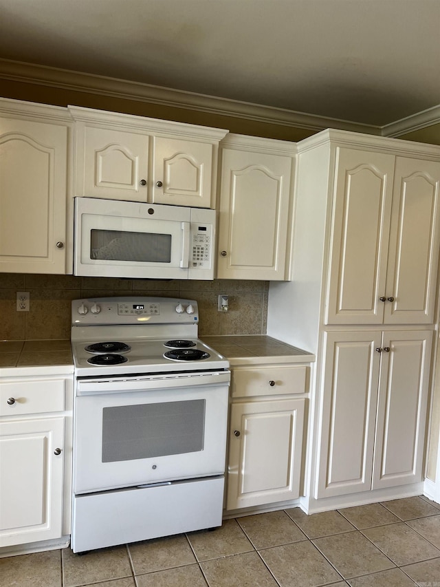 11 Willow Cv, Cabot, AR 72023 - kitchen with white appliances, light tile patterned flooring, backsplash, and ornamental molding