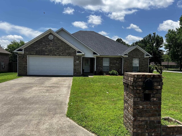 11 Willow Cv, Cabot, AR 72023 - view of front facade with driveway, a front yard, brick siding, an attached garage, and roof with shingles