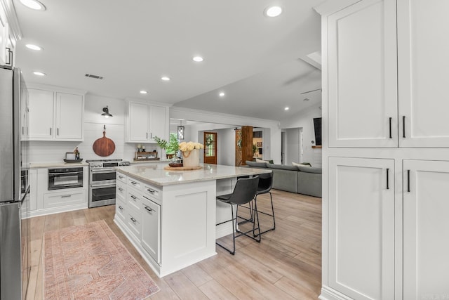 14320 Bradley Rd, Maumelle, AR 72113 - kitchen featuring stainless steel appliances, ornamental molding, a breakfast bar area, white cabinets, and open floor plan