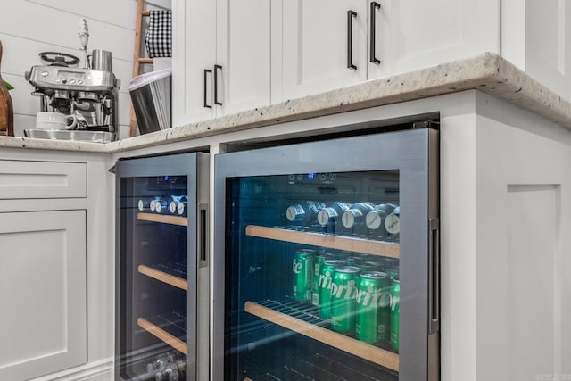14320 Bradley Rd, Maumelle, AR 72113 - kitchen view of wine cooler, white cabinetry, and light stone counters