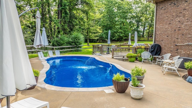 14320 Bradley Rd, Maumelle, AR 72113 - view of swimming pool featuring a patio, view of scattered trees, and a wooden deck