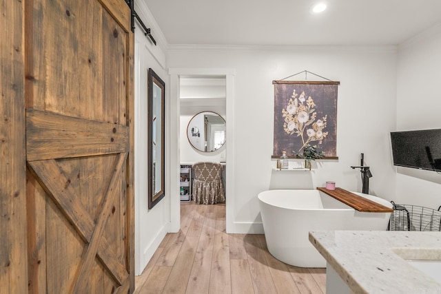14320 Bradley Rd, Maumelle, AR 72113 - full bath with a freestanding tub, vanity, wood-type flooring, crown molding, and recessed lighting
