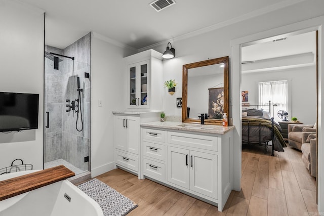 14320 Bradley Rd, Maumelle, AR 72113 - full bathroom with vanity, a stall shower, a freestanding bath, crown molding, and wood finished floors