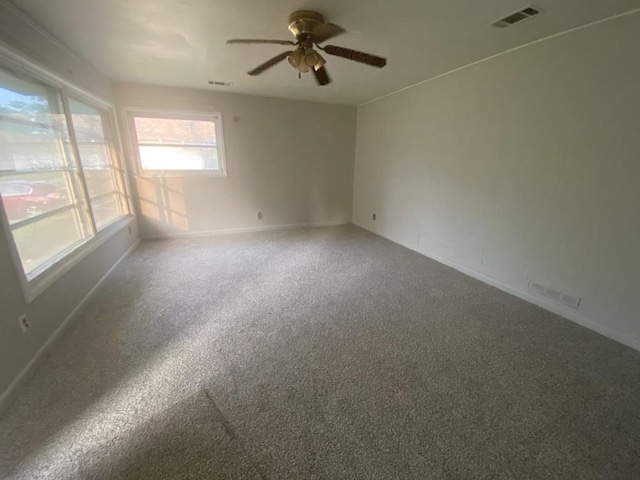unfurnished room with a ceiling fan, baseboards, and carpet