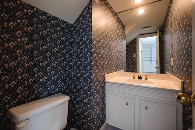 11 Bradbury Dr, Little Rock, AR 72212 - bathroom with wallpapered walls, toilet, lofted ceiling, vanity, and recessed lighting