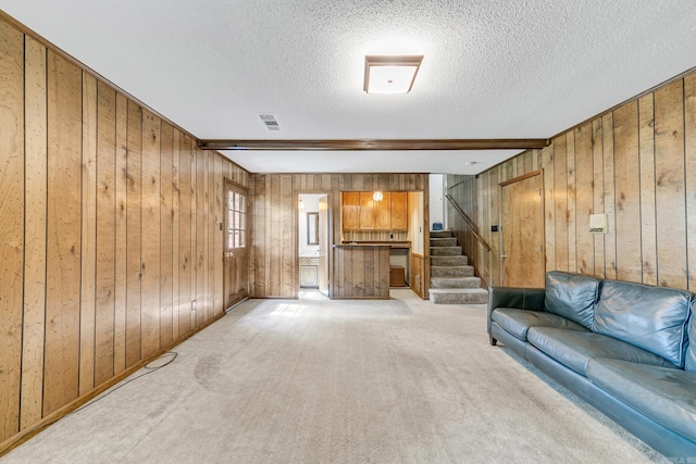 17 Point S Ct, Little Rock, AR 72211 - living area with wood walls, a textured ceiling, light carpet, and stairs