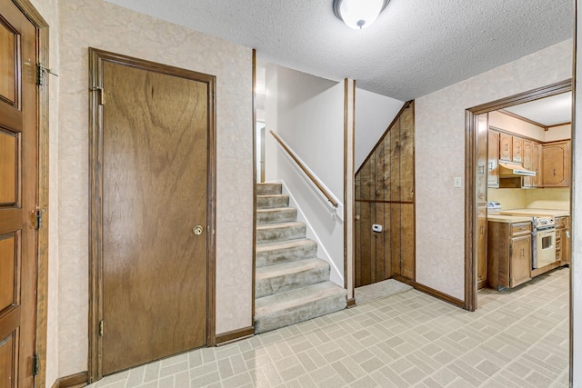 17 Point S Ct, Little Rock, AR 72211 - stairs with wallpapered walls, baseboards, a textured ceiling, and brick patterned floors