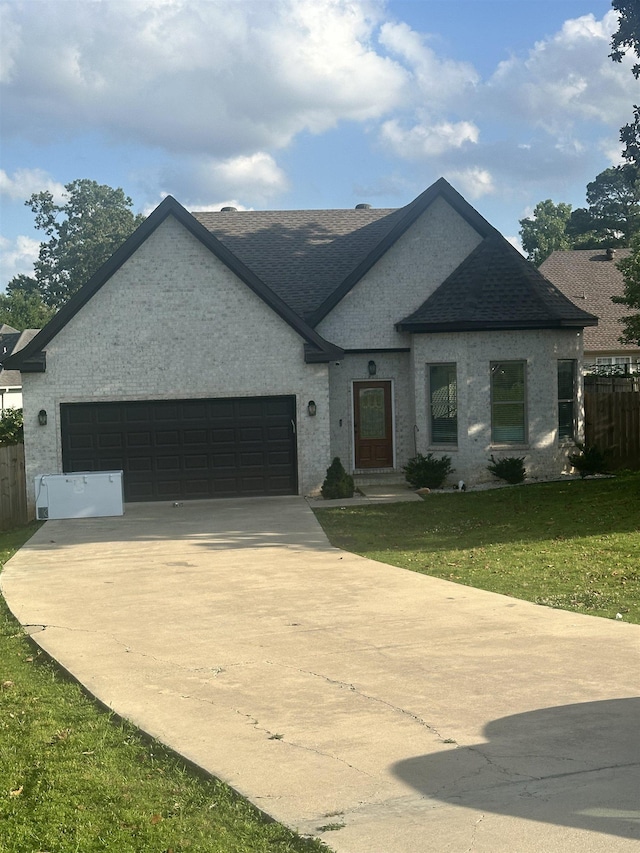 205 Capitol Cv, Jonesboro, AR 72401 - french country inspired facade featuring driveway, roof with shingles, a garage, and brick siding