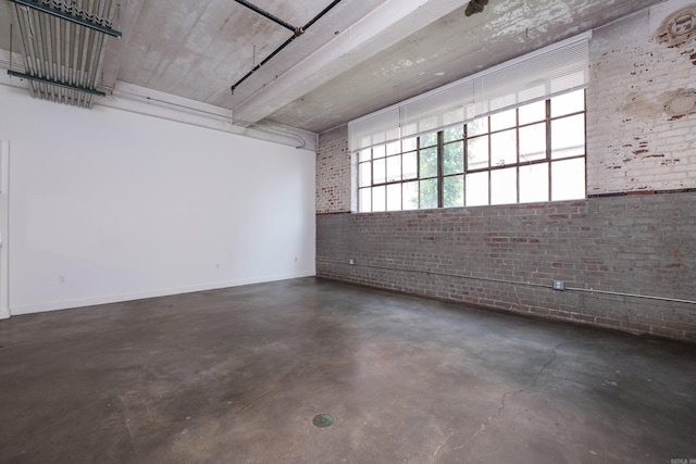 423 E 3rd St Unit 211, Little Rock, AR 72201 - unfurnished room featuring brick wall, concrete floors, and baseboards