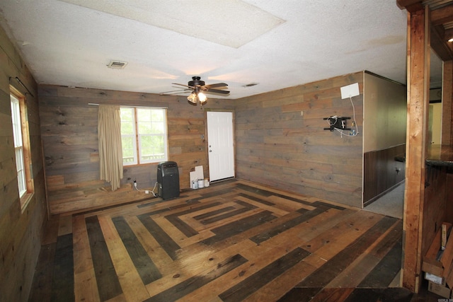 803 Reeder Rd, Leola, AR 72084 - empty room with wooden walls, ceiling fan, and a textured ceiling