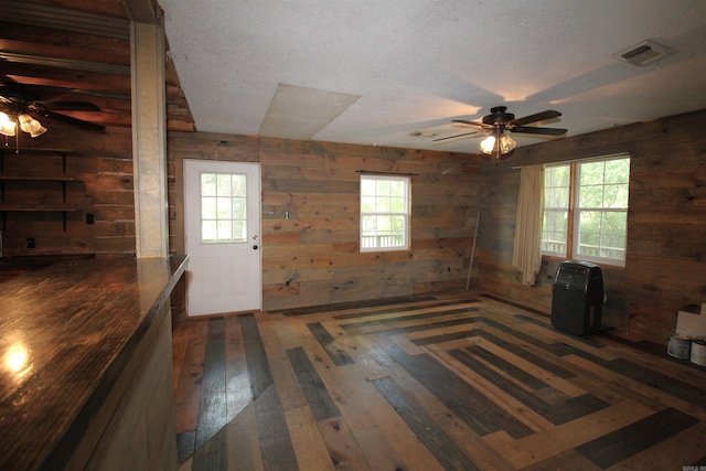 803 Reeder Rd, Leola, AR 72084 - foyer featuring a ceiling fan, wood walls, hardwood / wood-style floors, plenty of natural light, and a textured ceiling