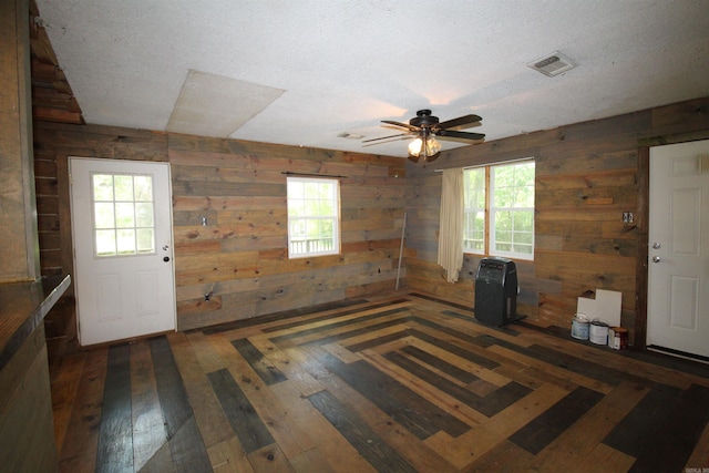 803 Reeder Rd, Leola, AR 72084 - unfurnished room with wooden walls, a ceiling fan, a textured ceiling, and hardwood / wood-style flooring