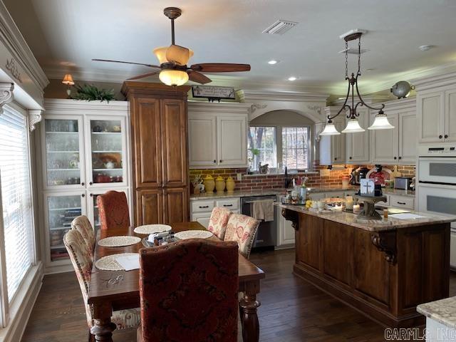 3165 Majestic Cir, Conway, AR 72034 - dining room featuring a ceiling fan, dark wood-type flooring, arched walkways, ornamental molding, and recessed lighting