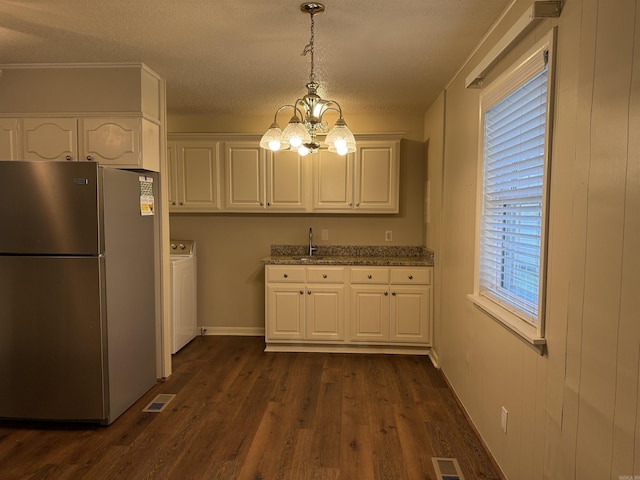913 Schriner Ct, North Little Rock, AR 72116 - kitchen with freestanding refrigerator, white cabinets, washer / clothes dryer, a chandelier, and healthy amount of natural light
