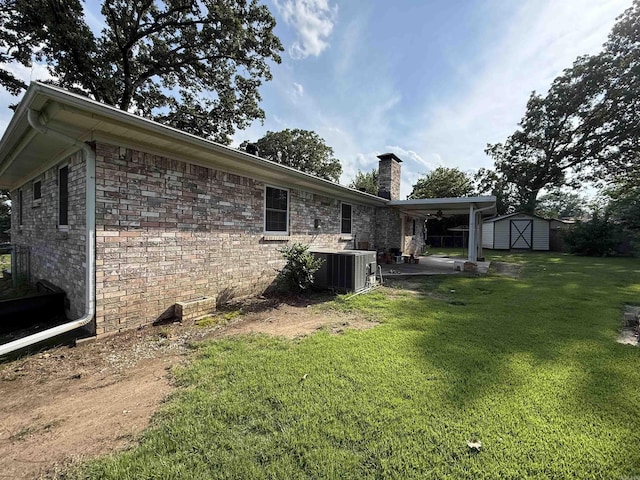 913 Schriner Ct, North Little Rock, AR 72116 - back of property with a patio area, a storage unit, a chimney, and a yard