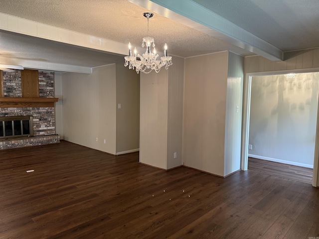 913 Schriner Ct, North Little Rock, AR 72116 - unfurnished living room featuring dark wood-style floors, a chandelier, beam ceiling, a large fireplace, and a textured ceiling