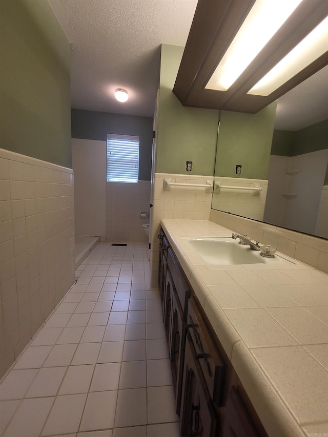 1008 W A Ave, North Little Rock, AR 72116 - full bathroom featuring tile walls, vanity, tile patterned floors, wainscoting, and a textured ceiling
