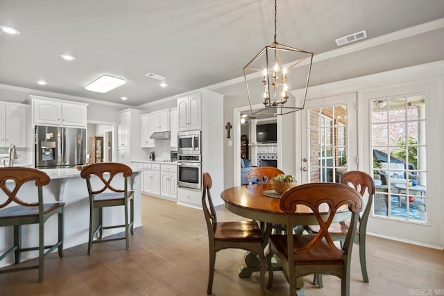 106 Hidden Falls Ln, Maumelle, AR 72113 - dining area featuring ornamental molding, a chandelier, light wood-type flooring, and recessed lighting