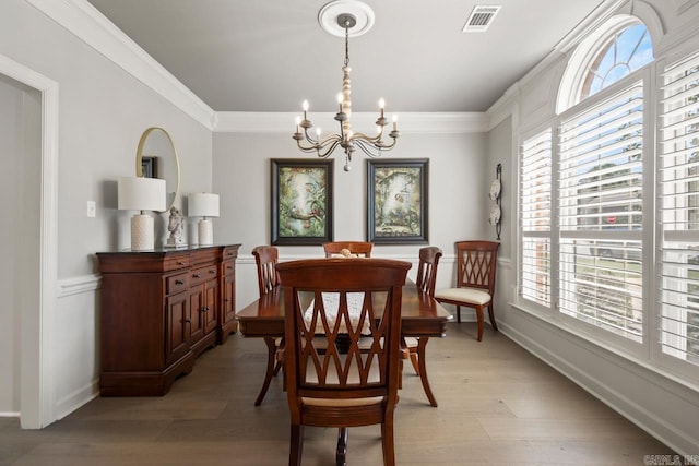 106 Hidden Falls Ln, Maumelle, AR 72113 - dining area with a chandelier, healthy amount of natural light, light wood-style flooring, crown molding, and a wainscoted wall
