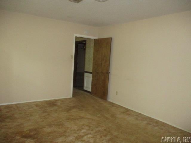 carpeted empty room with a ceiling fan