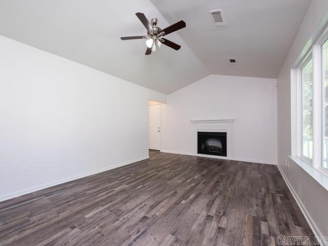 1121 Stewart St, Benton, AR 72015 - unfurnished living room with vaulted ceiling, ceiling fan, dark wood-style flooring, and a fireplace