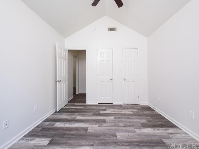 1121 Stewart St, Benton, AR 72015 - unfurnished bedroom with wood finished floors, a ceiling fan, and high vaulted ceiling