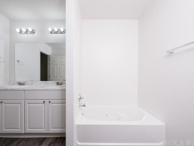 1121 Stewart St, Benton, AR 72015 - bathroom featuring a whirlpool tub, double vanity, and wood finished floors