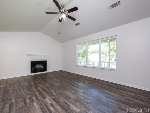 1121 Stewart St, Benton, AR 72015 - unfurnished living room with lofted ceiling, a ceiling fan, dark wood-style floors, and a fireplace