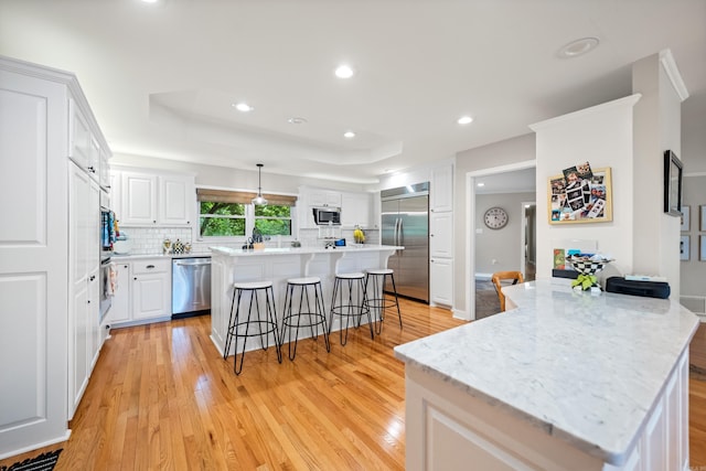 308 Bellaire, Hot Springs, AR 71901 - kitchen featuring appliances with stainless steel finishes, a kitchen bar, light wood finished floors, a kitchen island, and tasteful backsplash