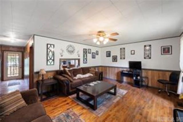 1440 N Shore Rd, Atkins, AR 72823 - living area with wood finished floors, wainscoting, a ceiling fan, and wood walls