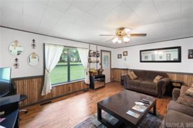1440 N Shore Rd, Atkins, AR 72823 - living area with a wainscoted wall, wooden walls, a ceiling fan, and wood finished floors