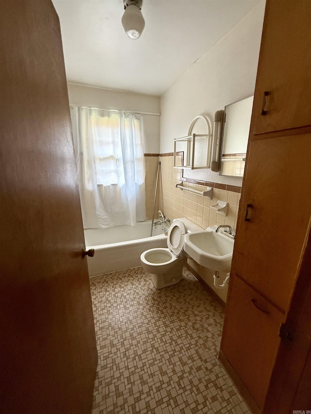 811 Hester St, Jonesboro, AR 72401 - bathroom with tile patterned floors, shower / bath combo with shower curtain, tile walls, and a wainscoted wall