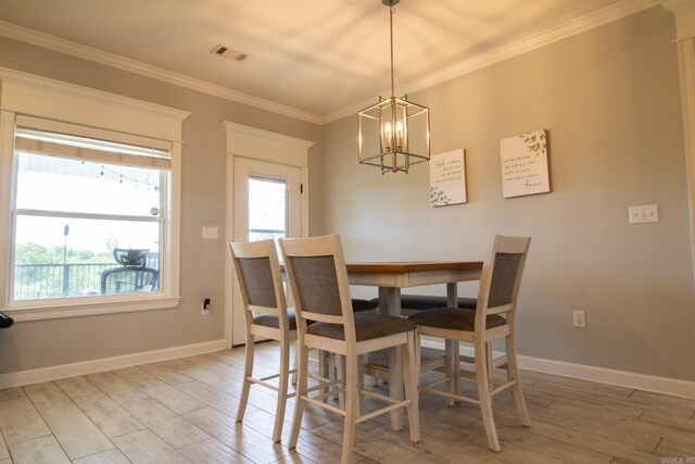 dining room featuring a chandelier, ornamental molding, and light wood-type flooring
