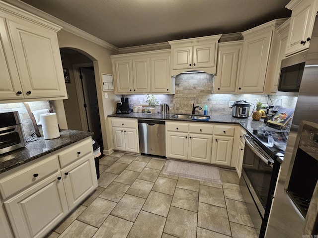 15 Marlin Dr, Austin, AR 72007 - kitchen featuring stainless steel appliances, arched walkways, tasteful backsplash, dark stone countertops, and crown molding