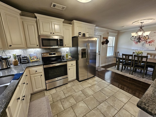 15 Marlin Dr, Austin, AR 72007 - kitchen featuring appliances with stainless steel finishes, tasteful backsplash, ornamental molding, a chandelier, and pendant lighting