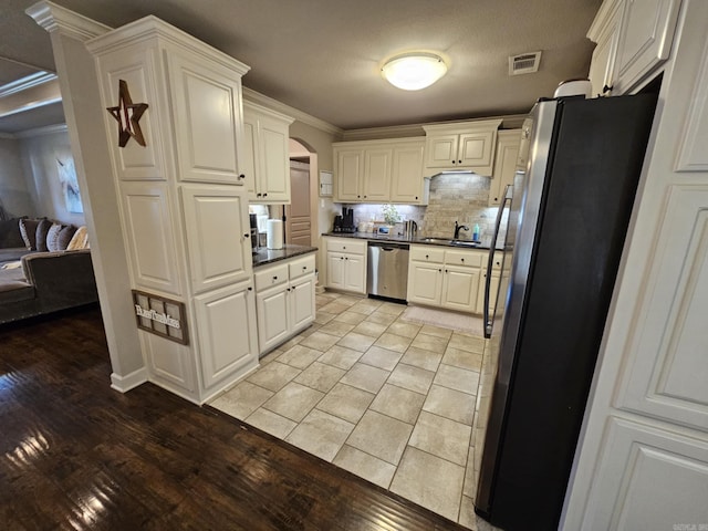 15 Marlin Dr, Austin, AR 72007 - kitchen featuring stainless steel appliances, arched walkways, dark countertops, tasteful backsplash, and ornamental molding