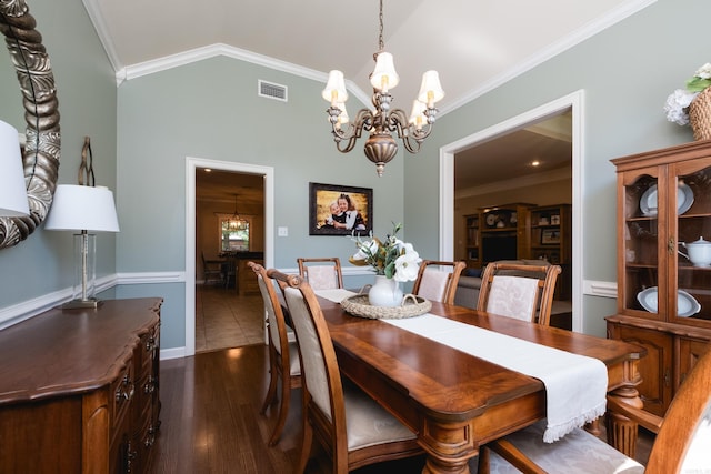 112 Holland Ln, Little Rock, AR 72223 - dining room with crown molding, a chandelier, dark wood-type flooring, and lofted ceiling
