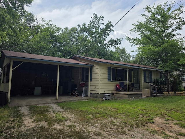 109 S Adams St, Mena, AR 71953 - rear view of property with dirt driveway, an attached carport, a lawn, and covered porch
