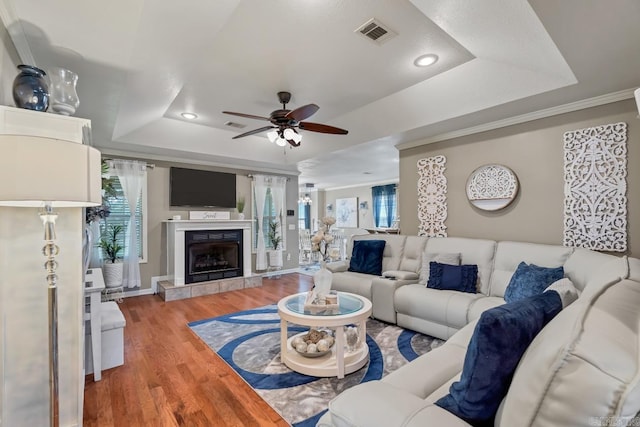 3612 Lexee Dr, Jonesboro, AR 72404 - living room featuring a tray ceiling, a ceiling fan, wood finished floors, a tiled fireplace, and recessed lighting
