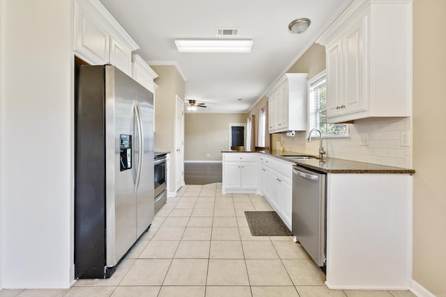 1228 Ridgecrest Dr, Benton, AR 72015 - kitchen with appliances with stainless steel finishes, white cabinets, backsplash, a ceiling fan, and ornamental molding