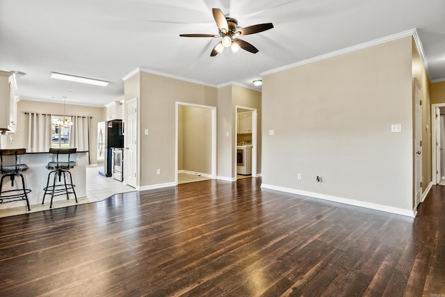 1228 Ridgecrest Dr, Benton, AR 72015 - unfurnished living room featuring a ceiling fan, wood finished floors, washer / clothes dryer, crown molding, and a chandelier