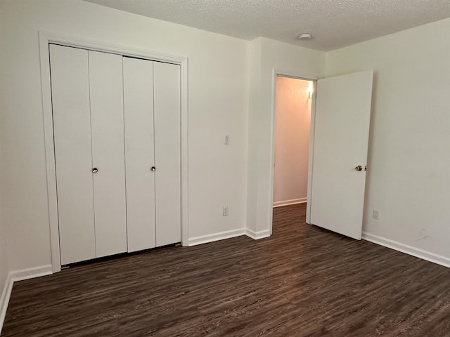 1502 E Emerald Cove Dr, Horseshoe Bend, AR 72512 - unfurnished bedroom with dark wood-style floors, a closet, and a textured ceiling