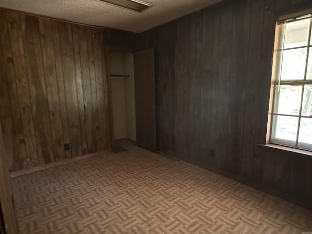 17811 Puckett Rd, Alexander, AR 72002 - empty room featuring wooden walls and a textured ceiling