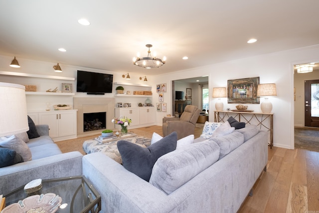 7 Shawbridge Ln, Little Rock, AR 72212 - living area featuring a fireplace with raised hearth, light wood-type flooring, a chandelier, recessed lighting, and plenty of natural light
