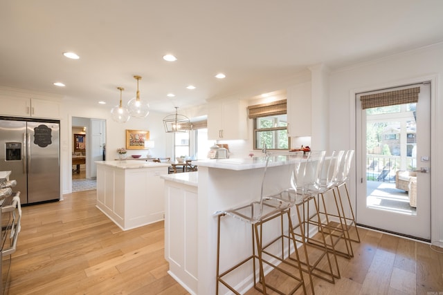 7 Shawbridge Ln, Little Rock, AR 72212 - kitchen featuring stainless steel fridge, light wood-type flooring, healthy amount of natural light, a peninsula, and recessed lighting